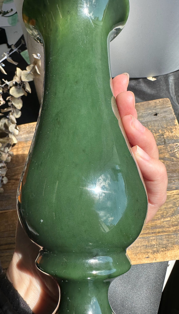 Hand-held Siberian Jade Vase showing its curved elongated body and glossy green glaze