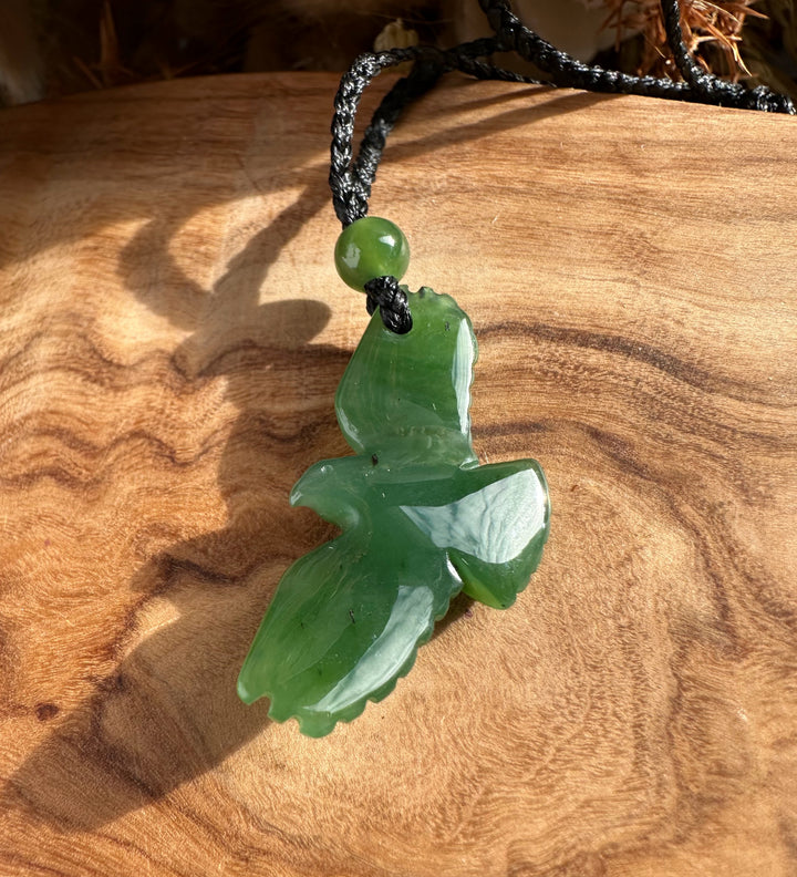 Green jade eagle pendant with round bead on a black braided cord necklace