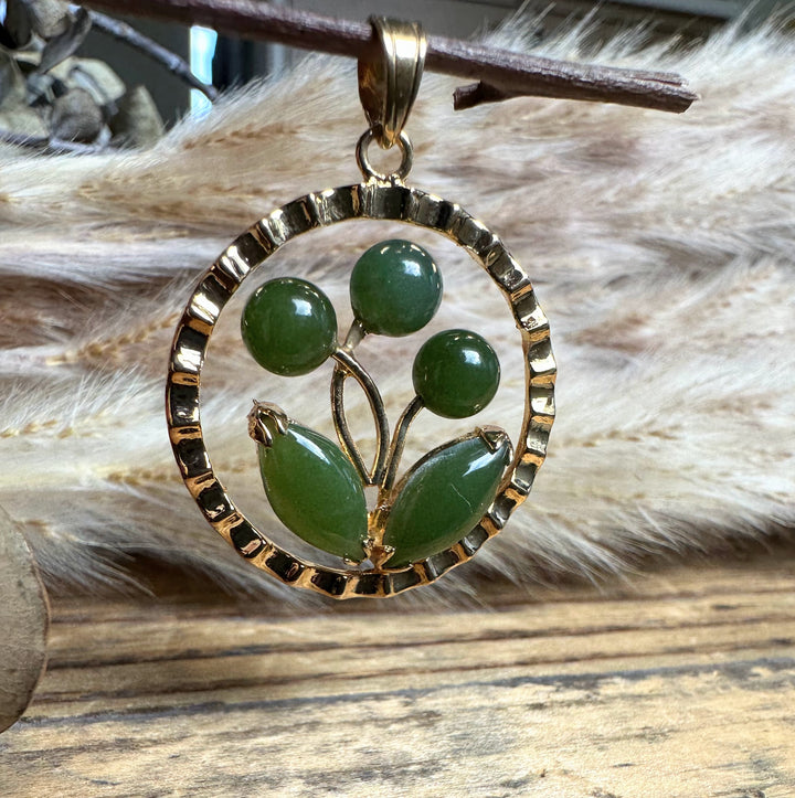 Vintage jade flower pendant with a textured gold circular frame and green jade beads
