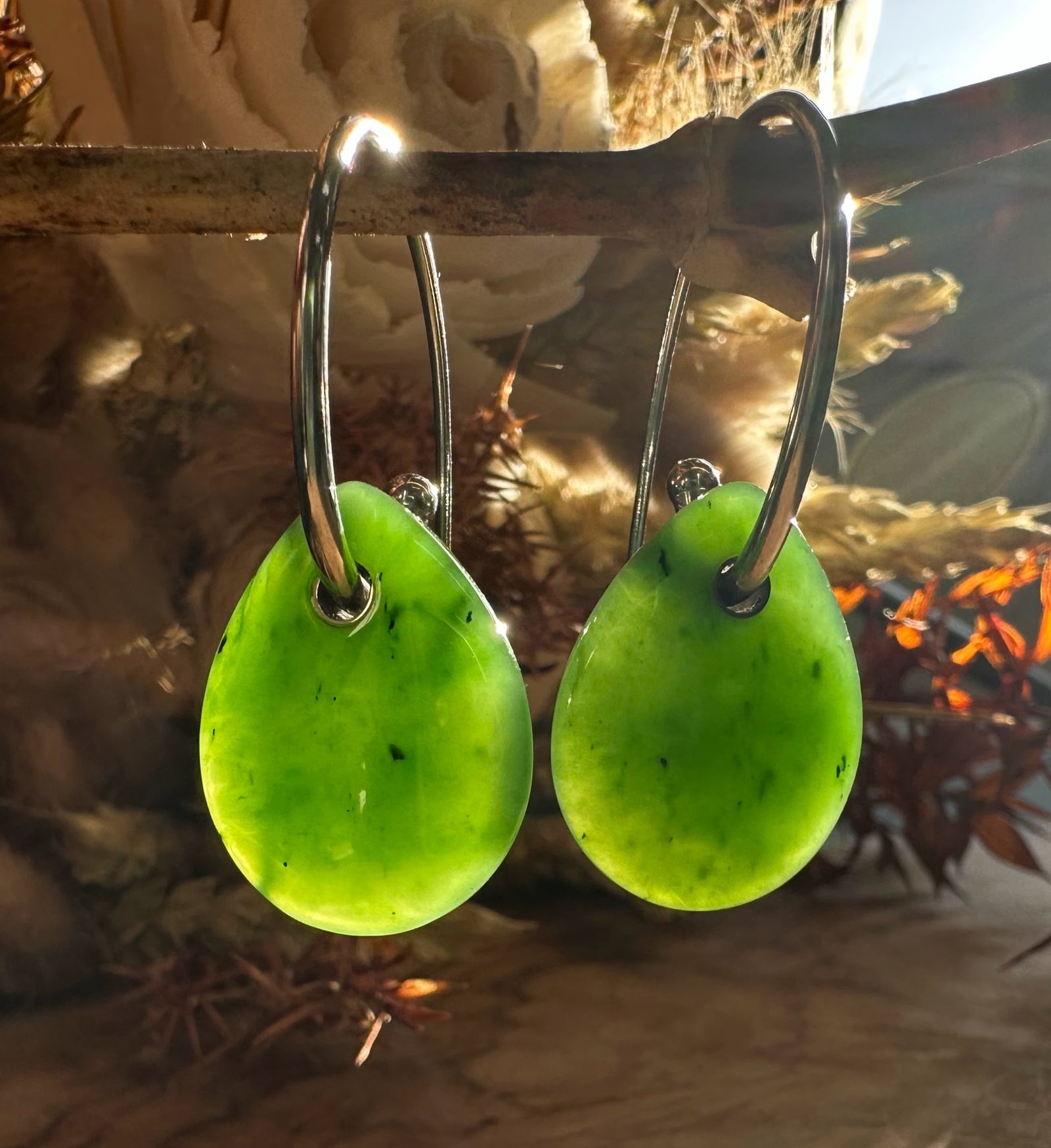 Pair of lime green jade teardrop earrings on silver hoops