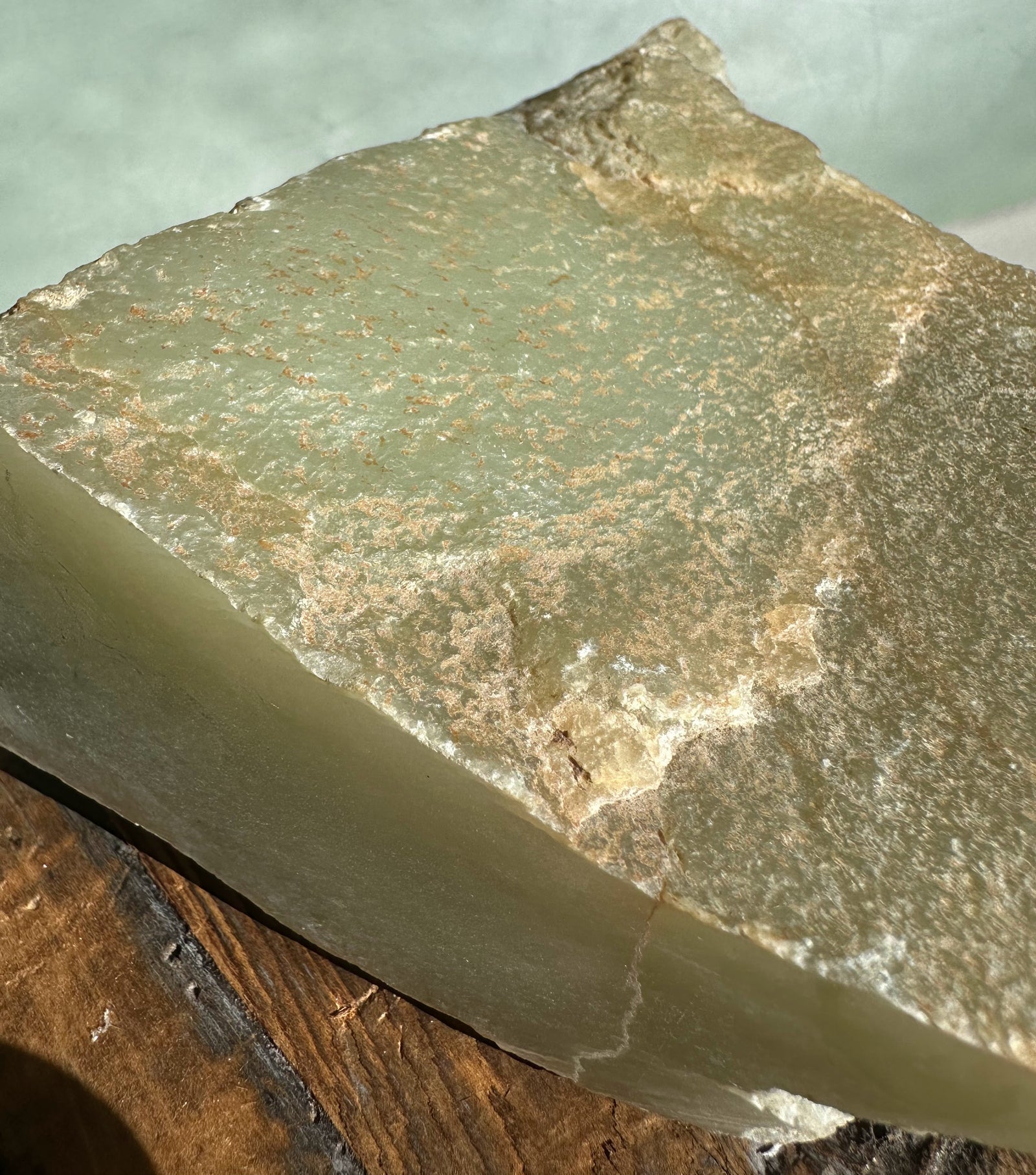 Korean Jade Rough slab with textured green surface and brown specks, showing a jagged top edge