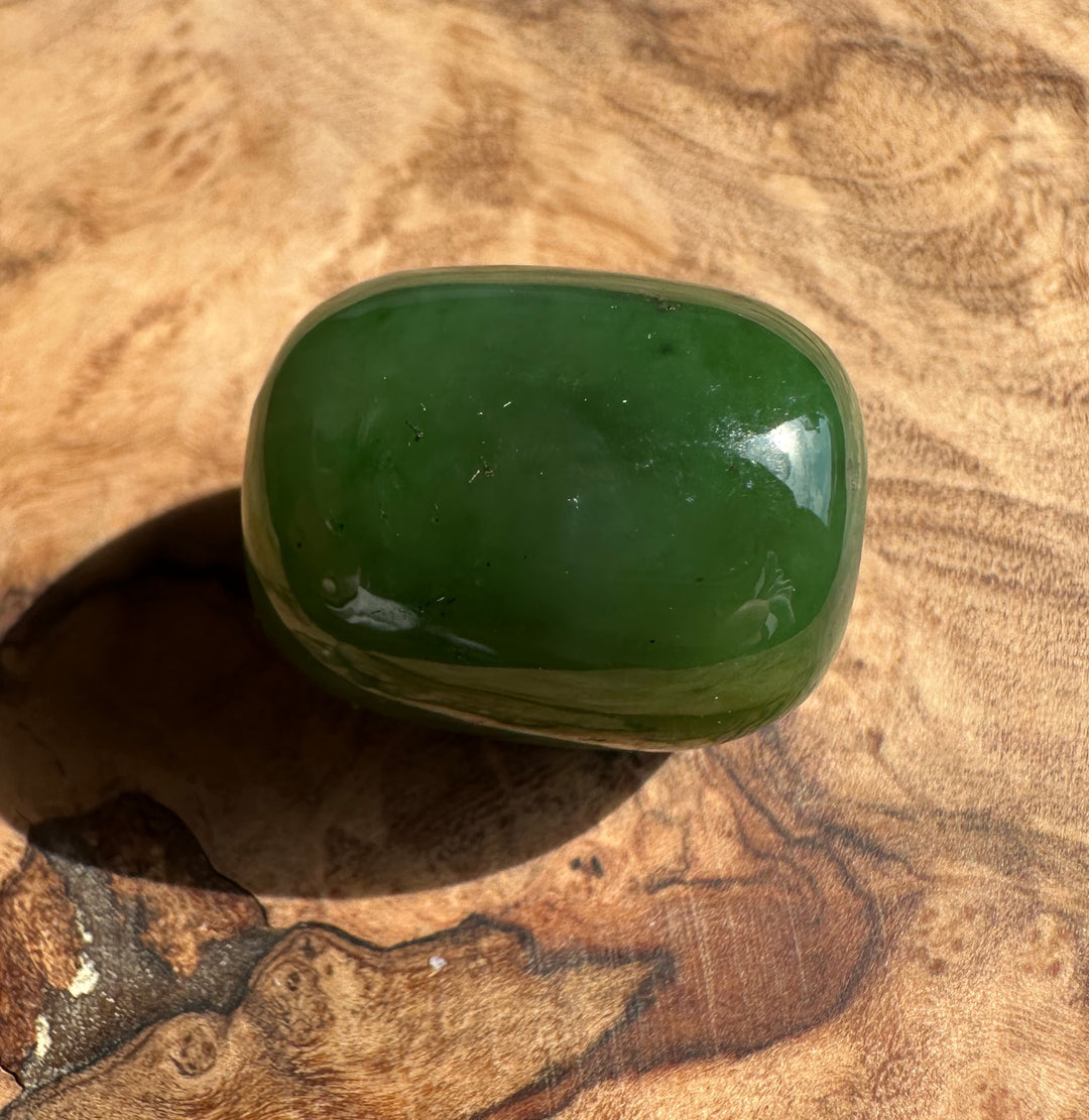 Single green Canadian jade bead 15x18 mm with a 2 mm hole on a wooden surface.