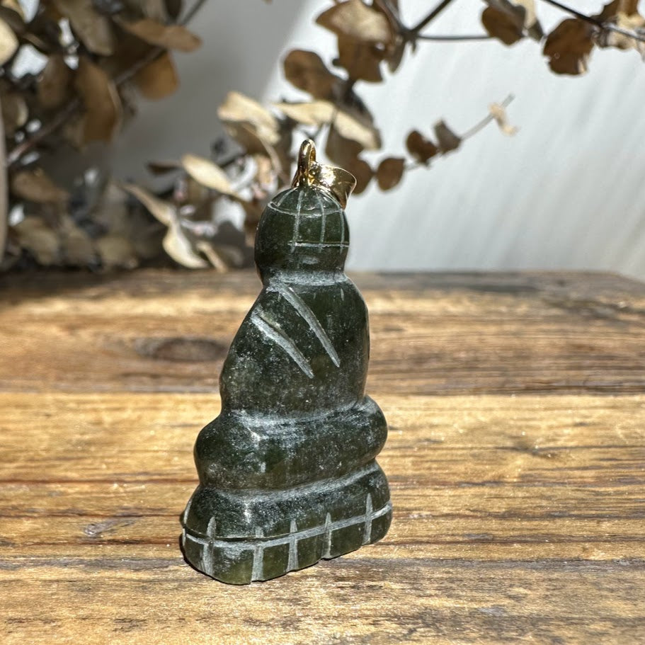 Back view of a dark green jade Buddha pendant with gold bail, showing carved robe details.