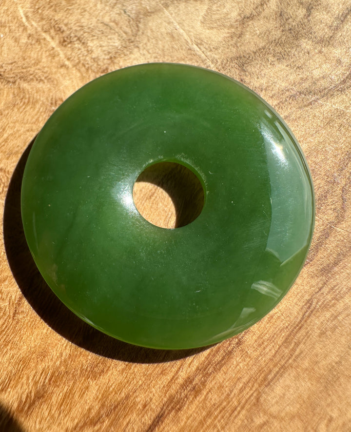 Green jade pi on a wooden surface
