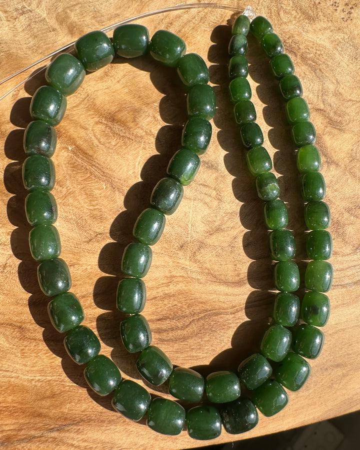 Dark Green Jade barrel shape beads on a wooden base