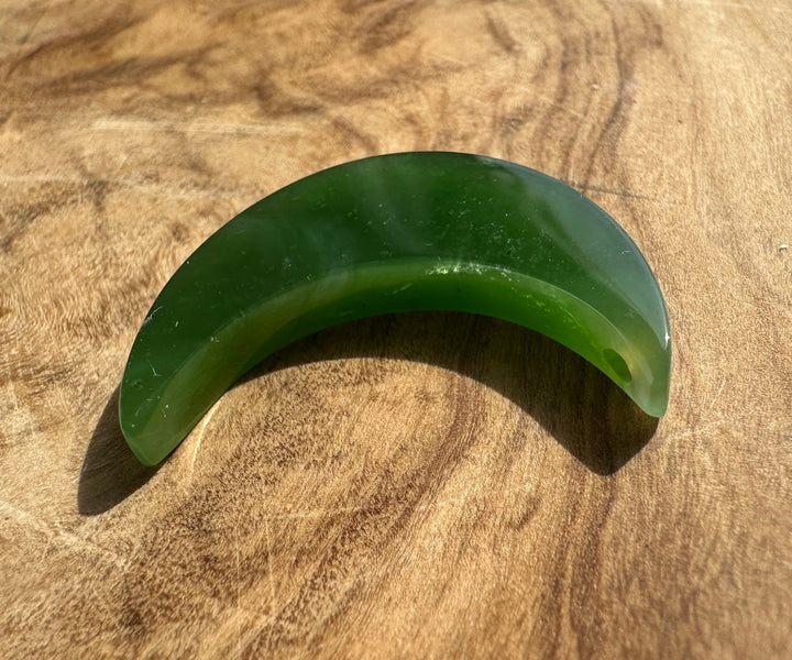 A crescent-shaped green jade textured wooden surface.