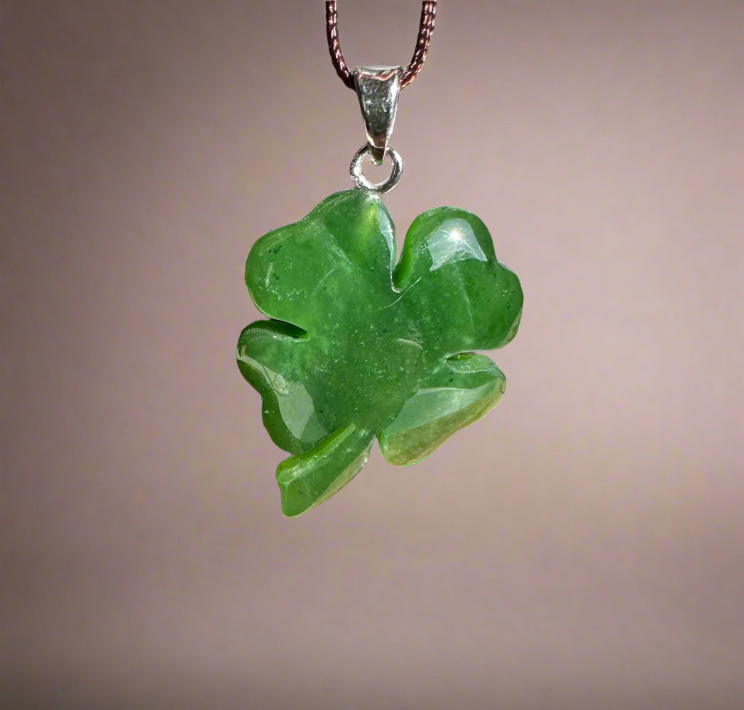 Green jade shamrock pendant with silver bail on a brown cord necklace