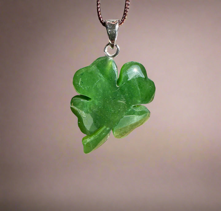 Green jade shamrock pendant with silver bail on a brown cord necklace
