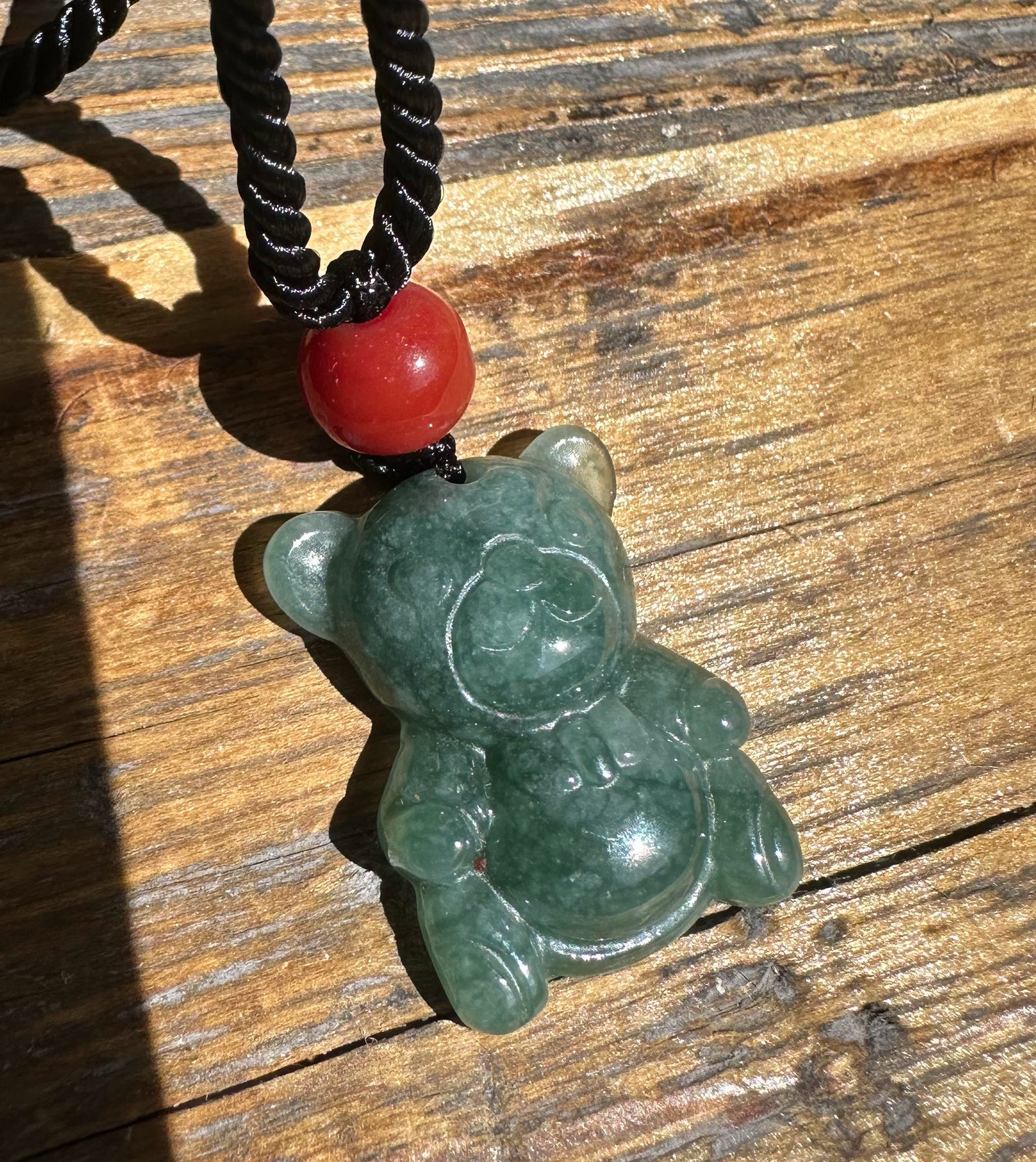 Guatemalan Jadeite Teddy Bear Pendant on a black braided cord with a red bead