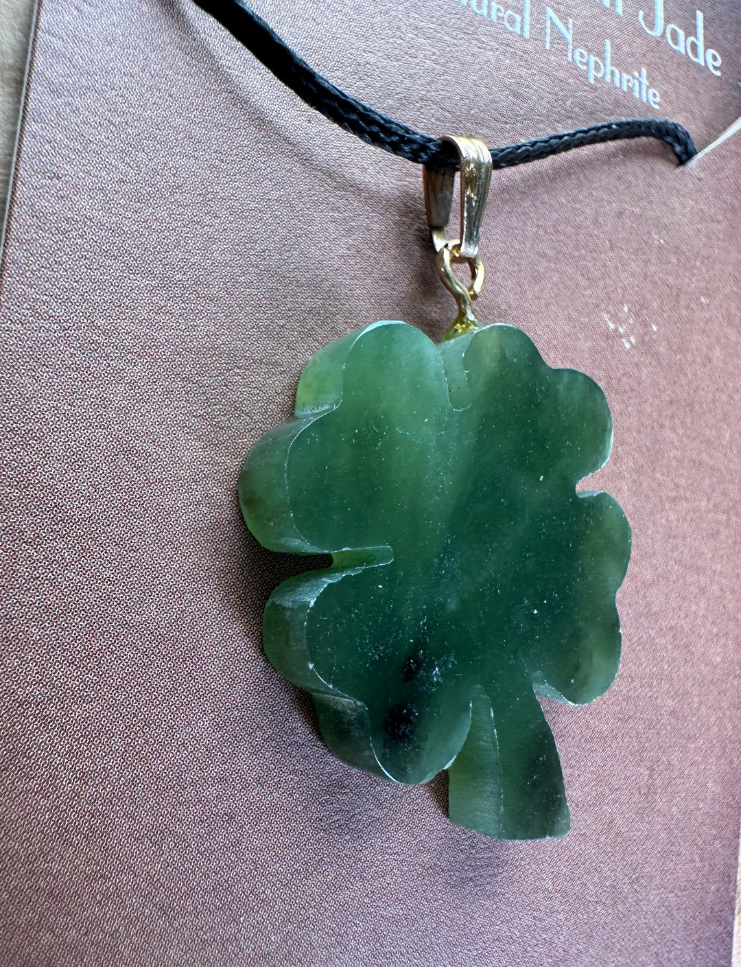 Vintage jade four leaf clover pendant on a black cord