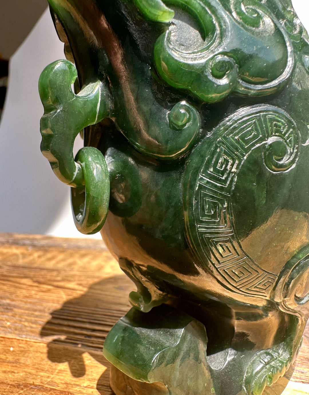 Dark green Canadian Jade Phoenix teapot close up with a curved ring handle and geometric side carving.