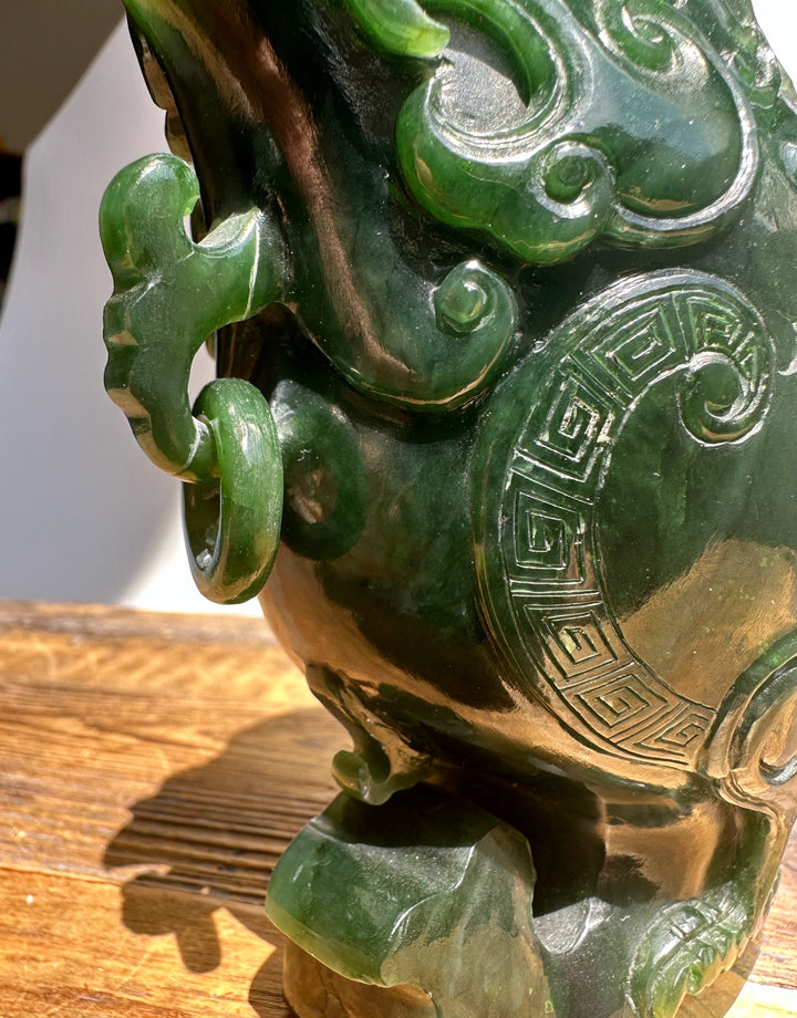 Dark green Canadian Jade Phoenix teapot close up with a curved ring handle and geometric side carving.