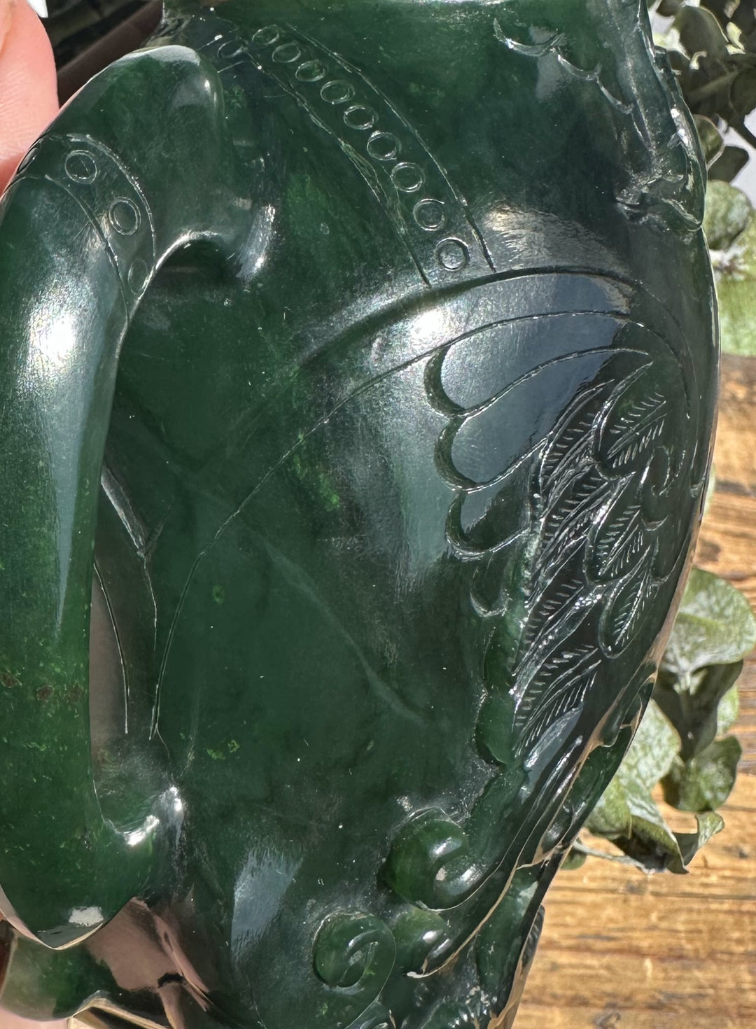 Front view of dark green jade phoenix teapot with leaf and wave relief patterns