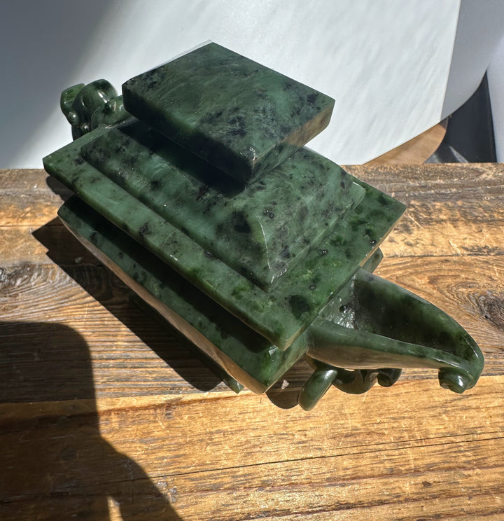 Canadian River Jade Teapot with stacked square layers in dark green jade and a curved handle on a wooden surface