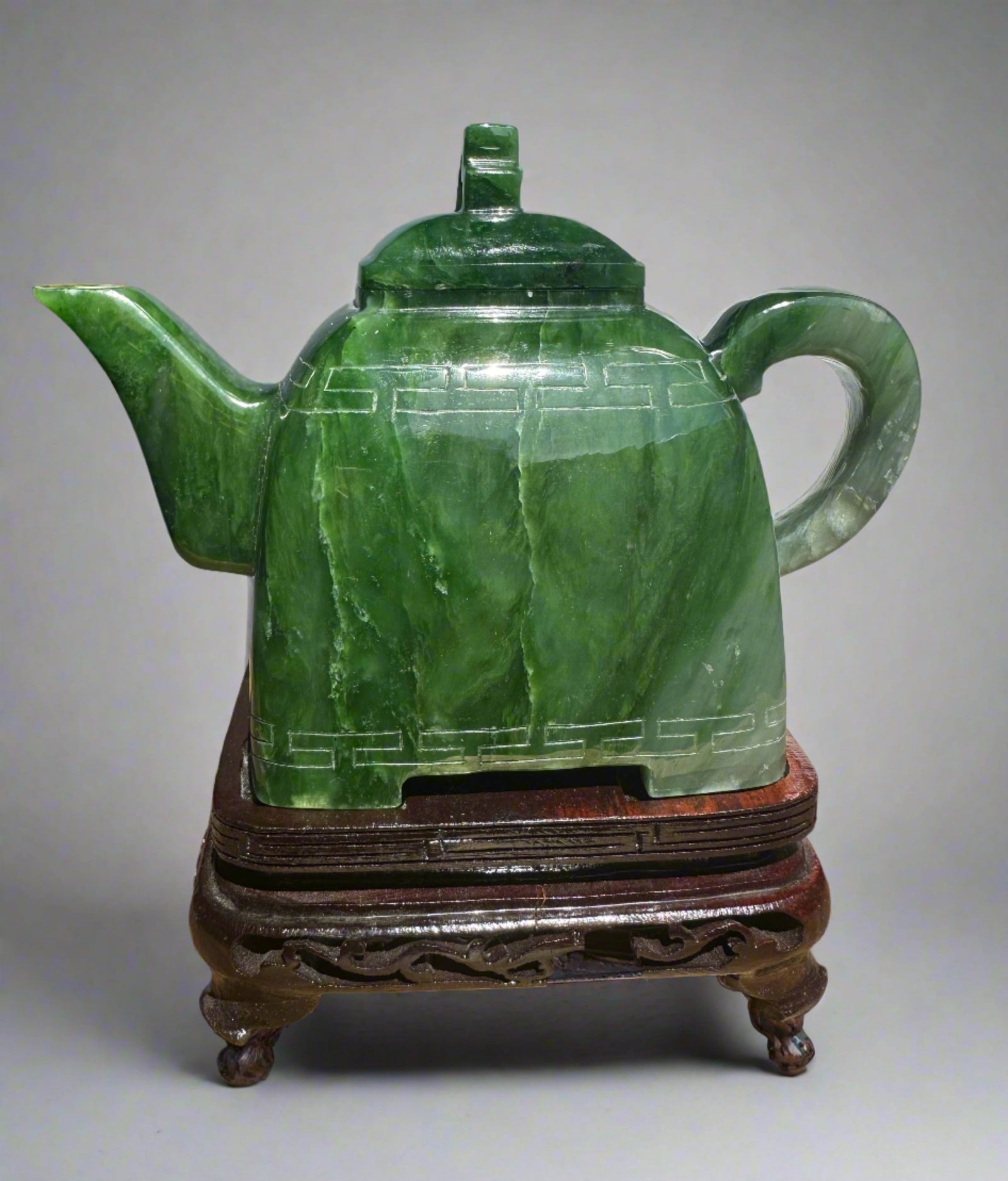 Polar Jade Teapot seven inches tall with a geometric band around the body, lid, spout left and curved handle on a neutral backdrop