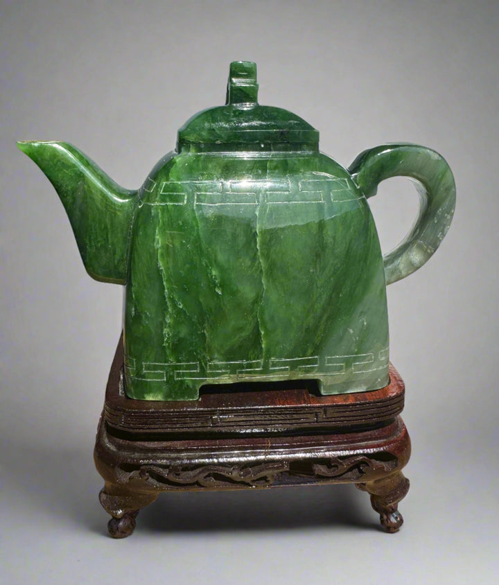 Polar Jade Teapot seven inches tall with a geometric band around the body, lid, spout left and curved handle on a neutral backdrop