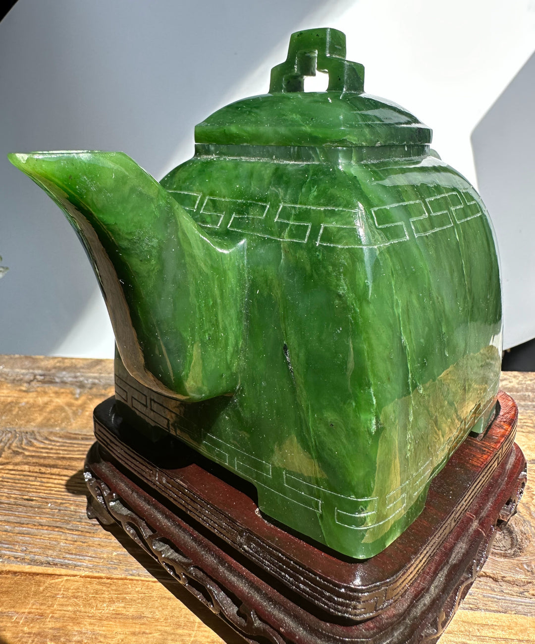 Close up of Polar Jade Teapot 7 showing a broad curved spout, large handle, and incised geometric banding on green jade