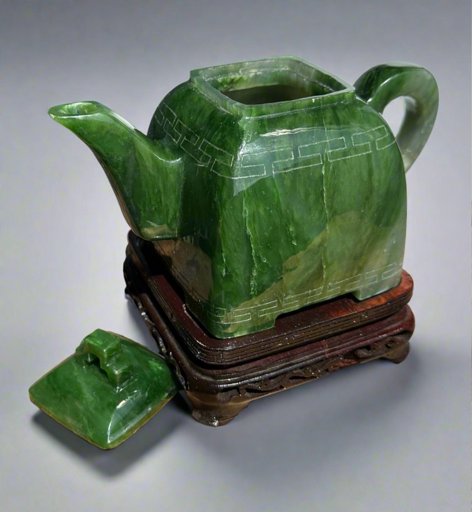 Polar Jade Teapot seven inches on a carved wooden stand with its lid removed and a separate lid nearby.