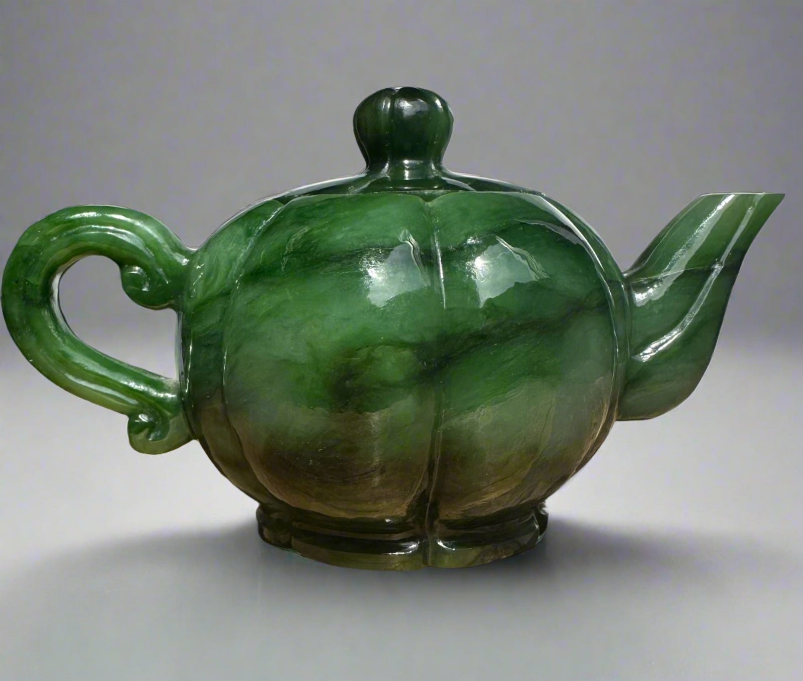 Polar Jade Teapot with a bulbous green marbled body curved handle and angular spout topped by a knobbed lid