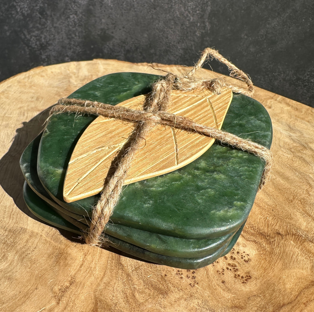 Green jade coasters tied with rustic twine and a wooden leaf-shaped accent on top