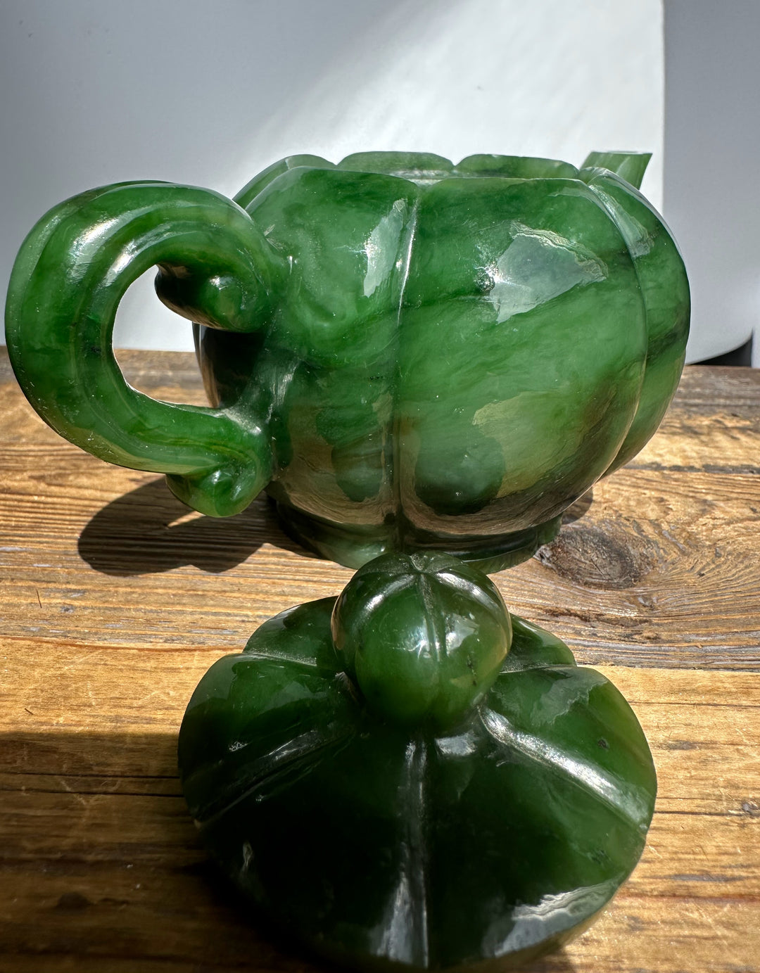 Polar Jade teapot with a rounded bulbous body and curved handle on a wooden surface.