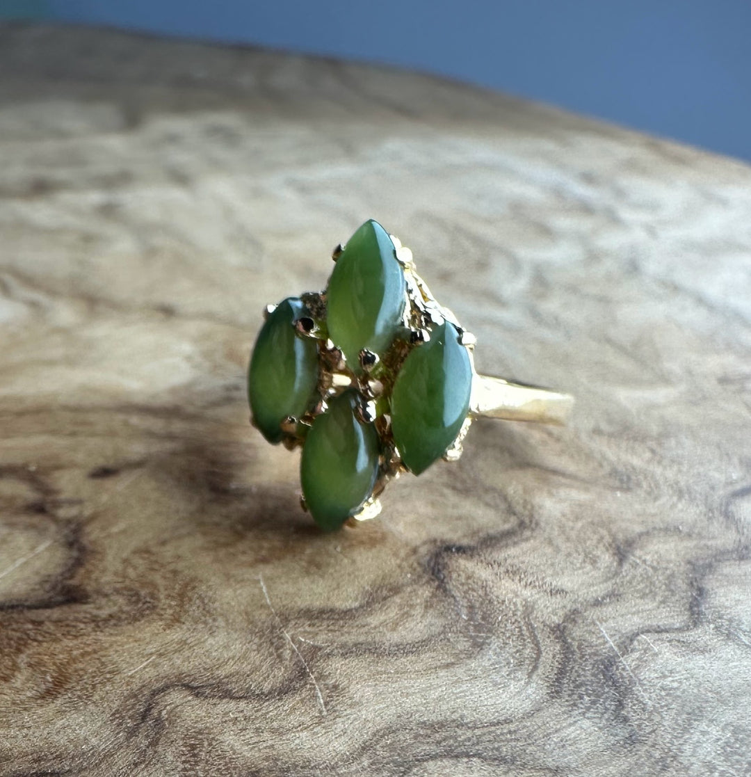 Close-up of vintage green jade cluster ring showing five marquise stones in a gold setting.