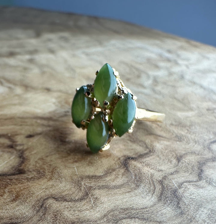 Close-up of vintage green jade cluster ring showing five marquise stones in a gold setting.