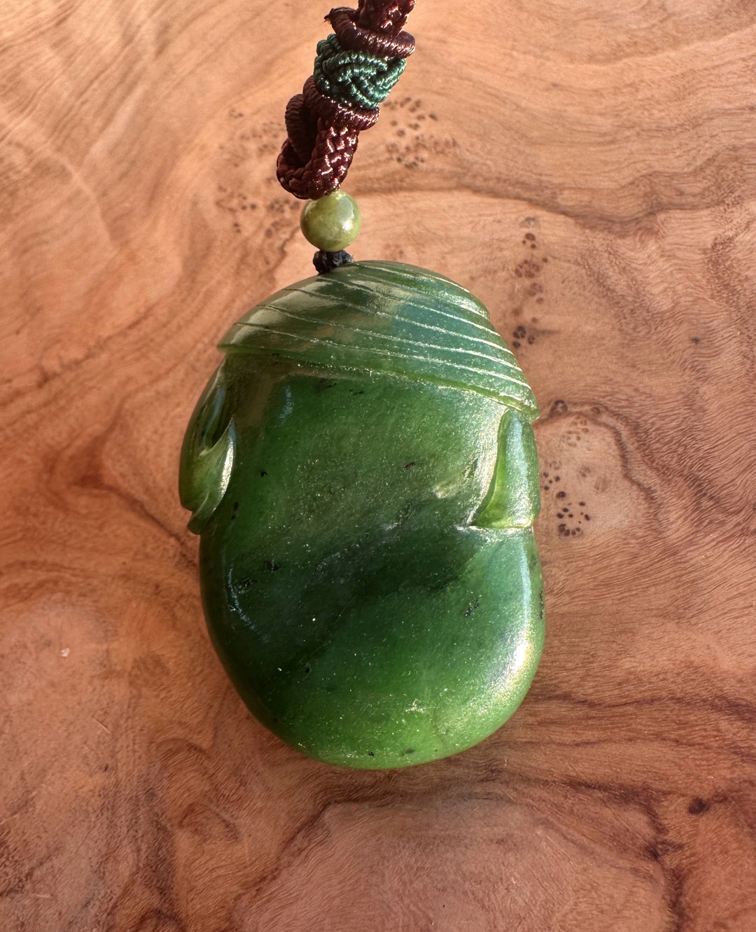 Green jade pig pendant carved from Canadian jade, 46mm, hanging on a braided cord with a green bead