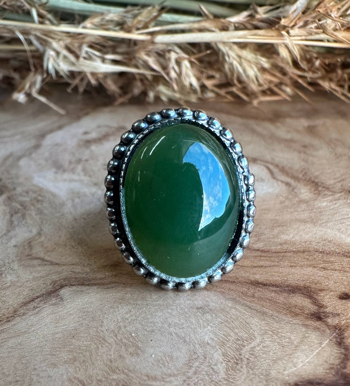 Vintage green Canadian jade ring in silver and steel with an oval cabochon and beaded bezel.