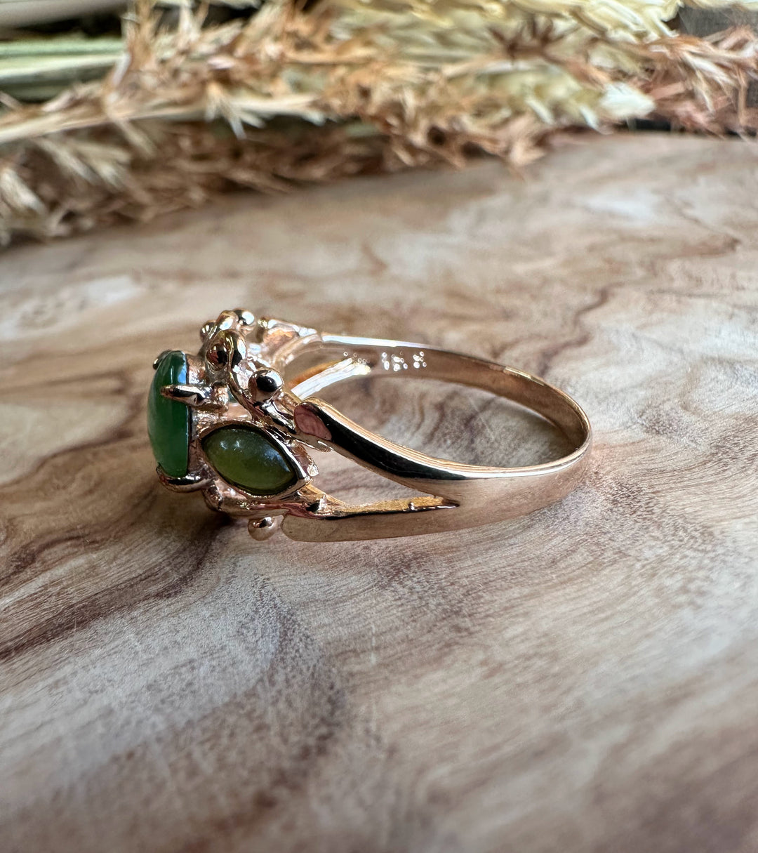 Side angle of Vintage Jade Mask Ring with a large central green jade cabochon and two matching side stones in a sculpted silver band