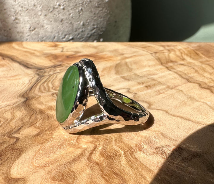 Canadian Jade and Silver Ring shown from the side with a large green oval jade and a textured silver setting.