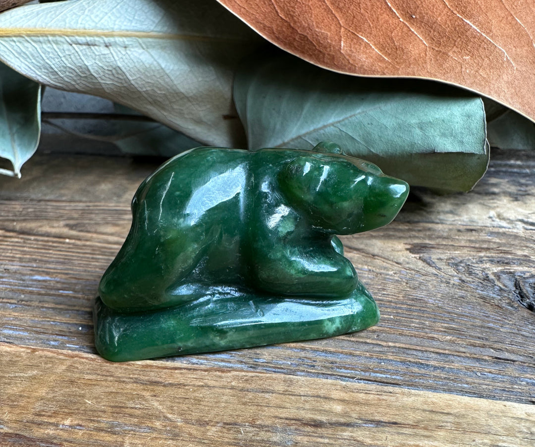 Front facing view of the green jade bear sculpture on a wooden surface