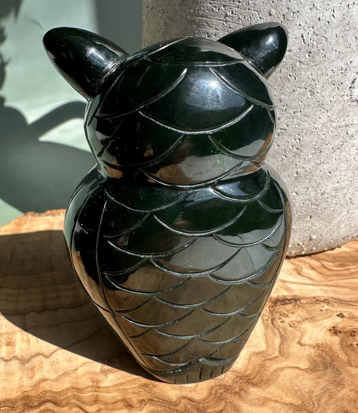 Back view of a dark green jade owl with feather scallop carving and a glossy finish