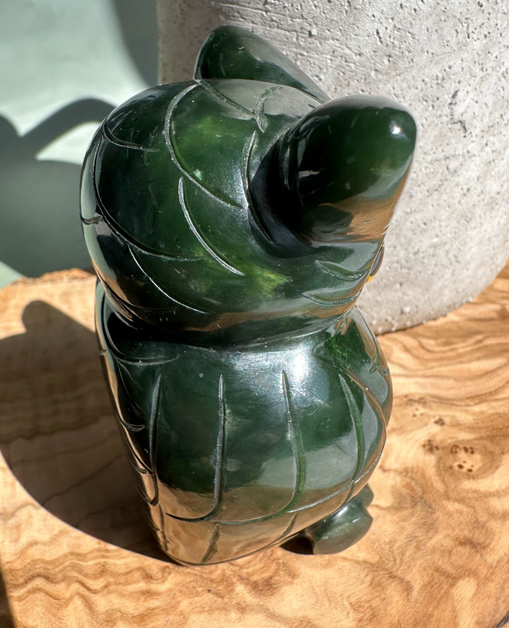 Back view of dark green jade owl with carved feather details