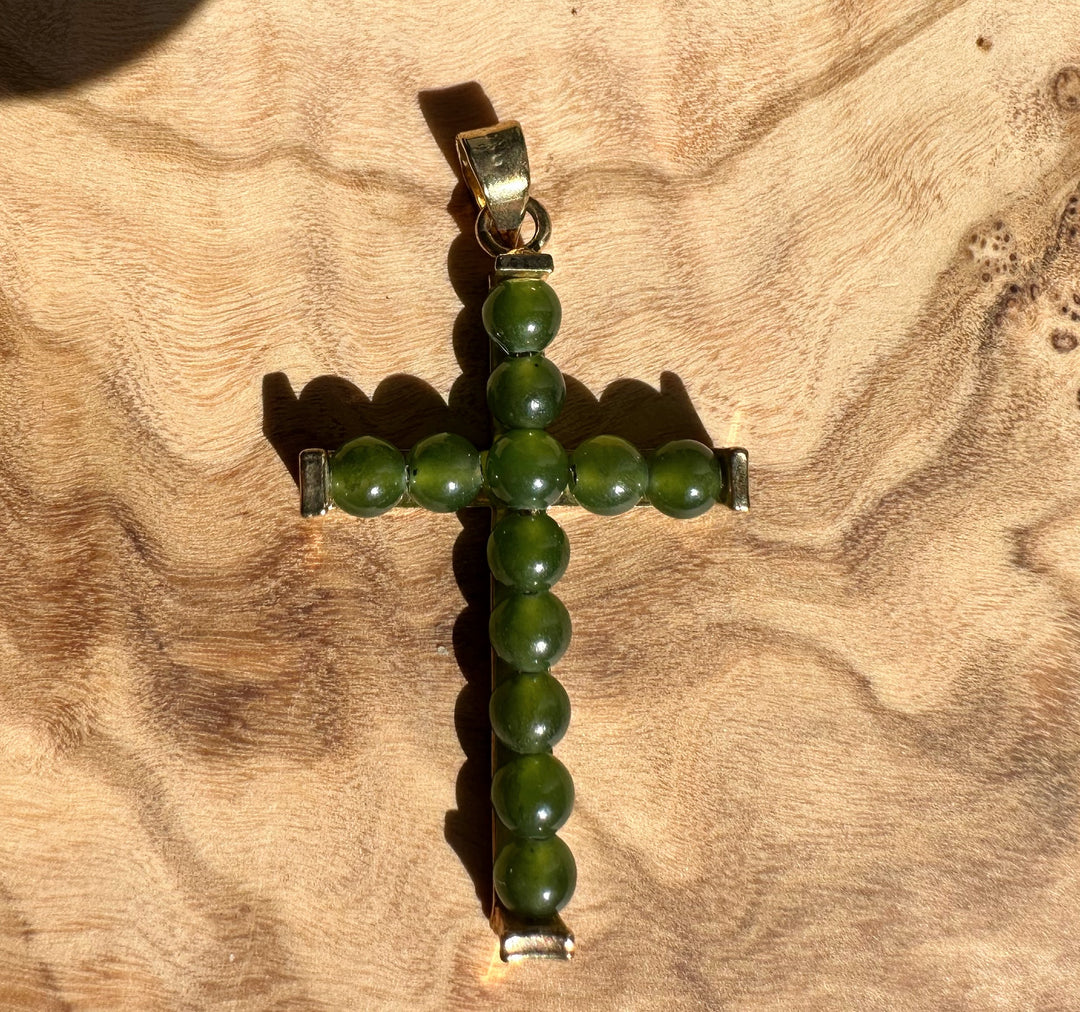 Vintage Jade Cross pendant with green round beads and metal fittings on wood background