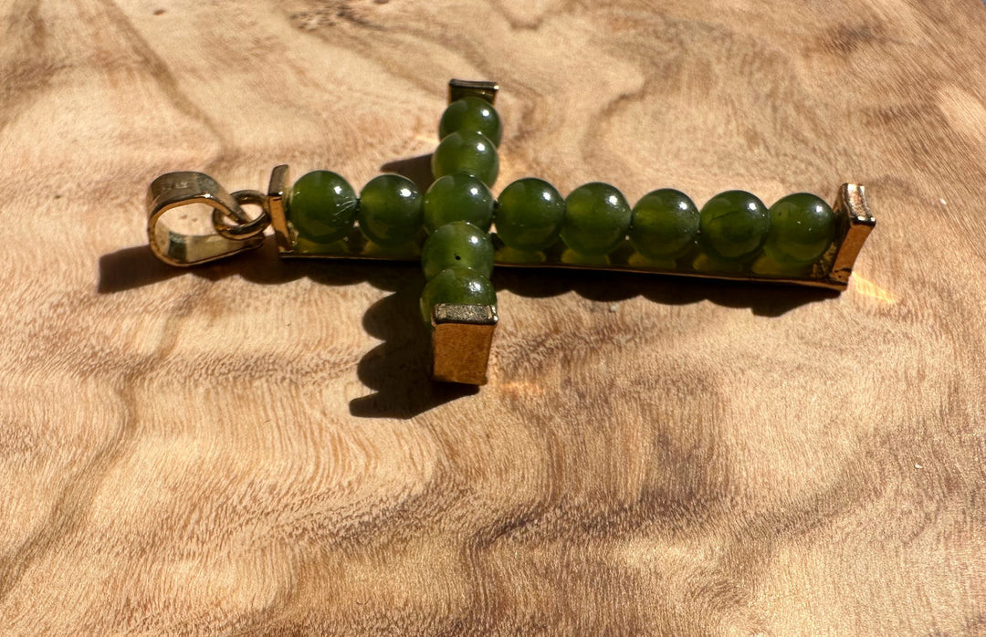 Vintage Jade Cross pendant oriented sideways showing a green bead cross with metal end caps