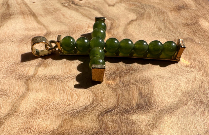 Vintage Jade Cross pendant oriented sideways showing a green bead cross with metal end caps
