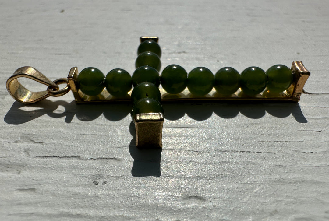 Jade bead cross pendant with green beads along a gold rectangular bar and a left side bail.