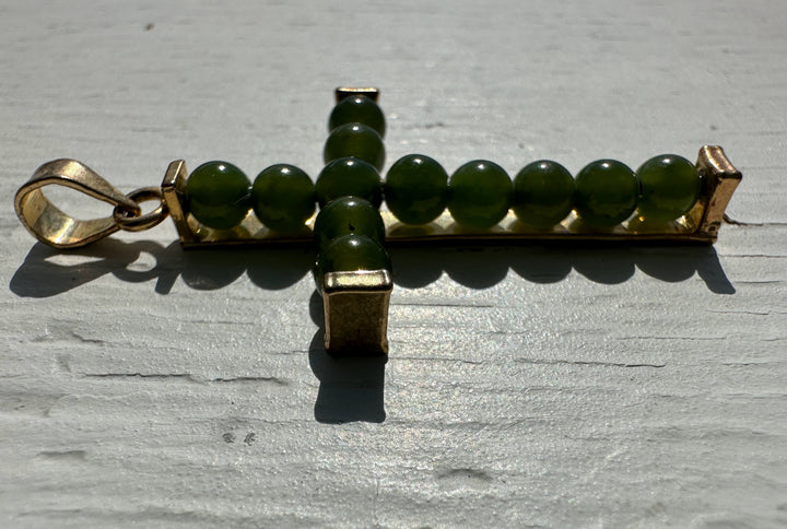 Jade bead cross pendant with green beads along a gold rectangular bar and a left side bail.