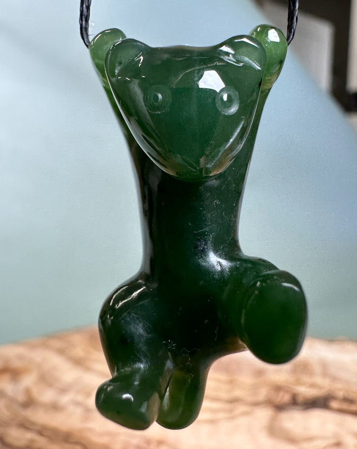Front view of green cat pendant on a cord with defined paws