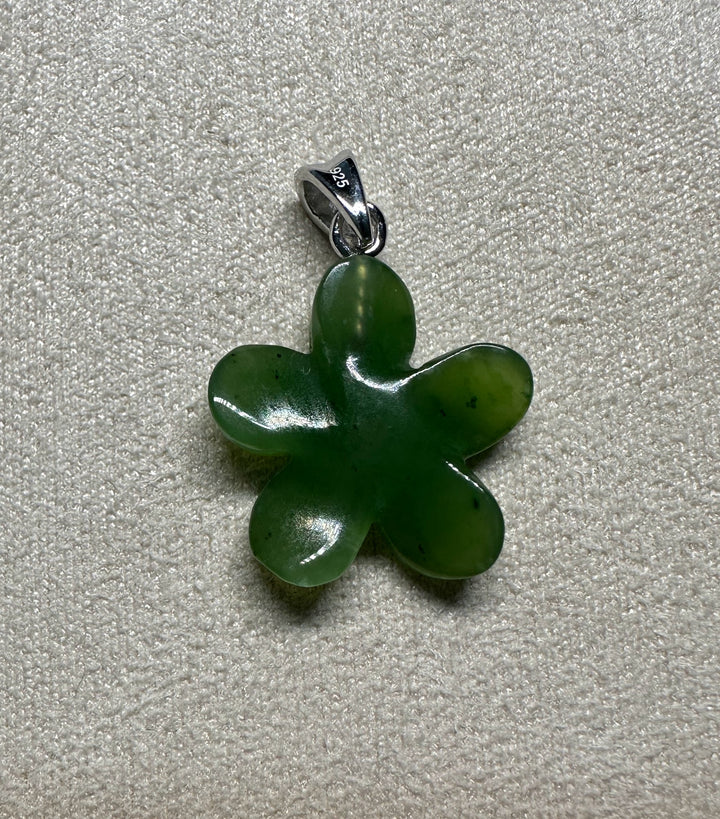 Close up of green jade Forget Me Knot flower pendant with a 925 sterling silver bail.