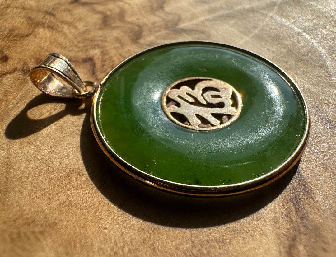 Close up of the gold bail and ring attached to the jade Fu Pi disc pendant.