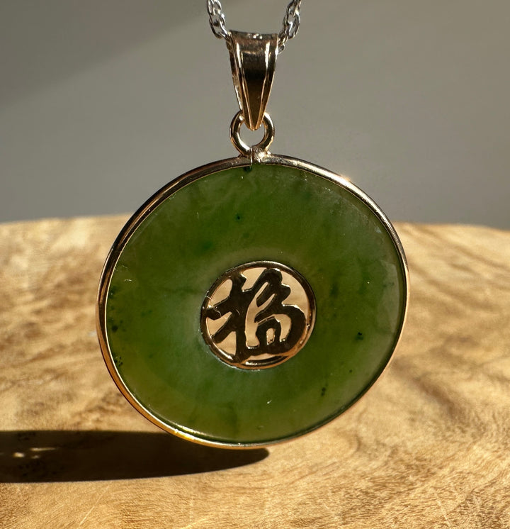 Green nephrite jade Fú Pi disc pendant in a silver setting with copper-toned bail and chain.