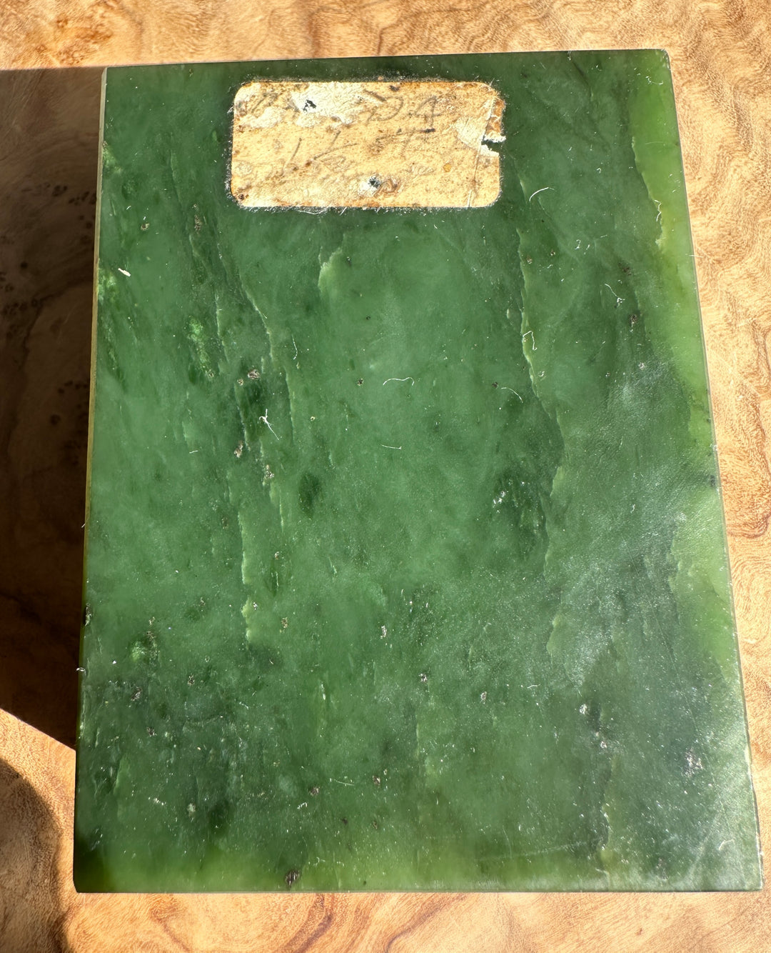 Dark green Canadian rough jade block with a worn label on top