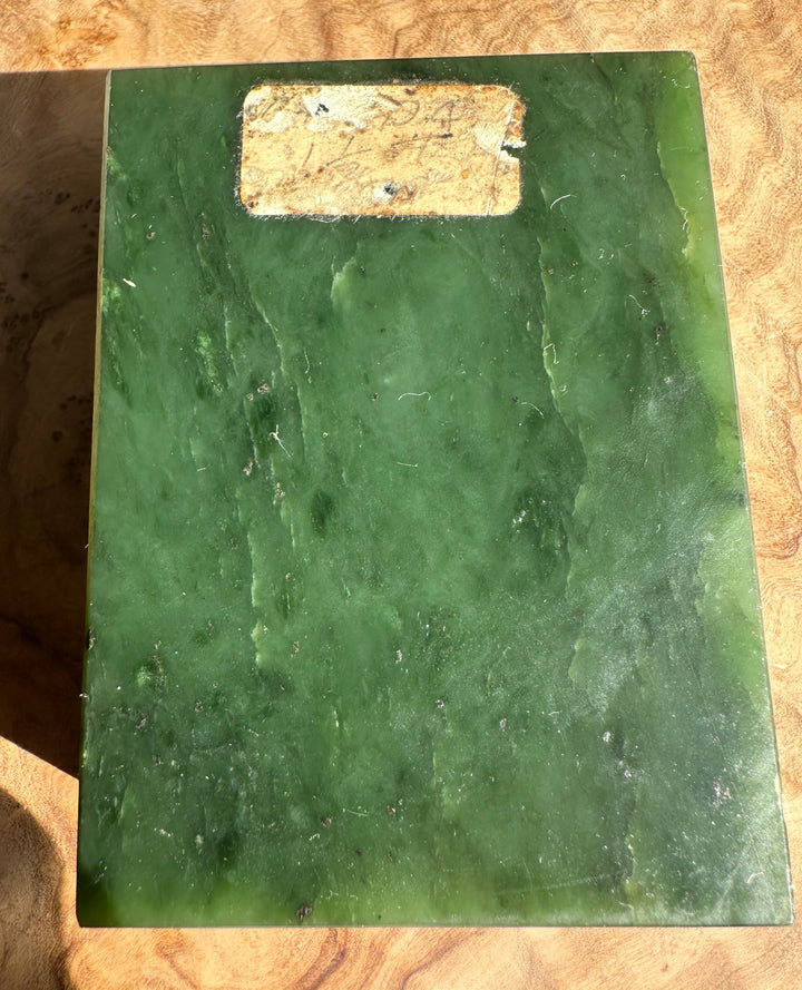 Dark green Canadian rough jade block with a worn label on top