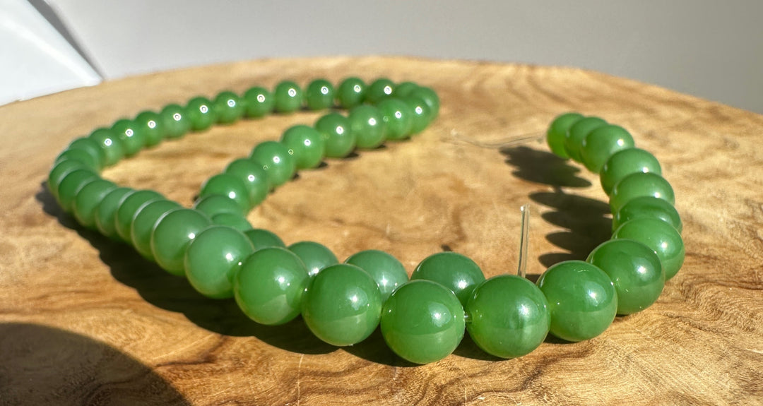 Close up of 8mm AA grade Siberian jade beads on a string, unstrung 16 inch strand