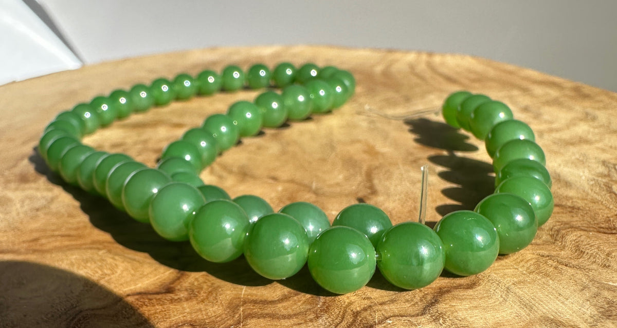 Close up of 8mm AA grade Siberian jade beads on a string, unstrung 16 inch strand