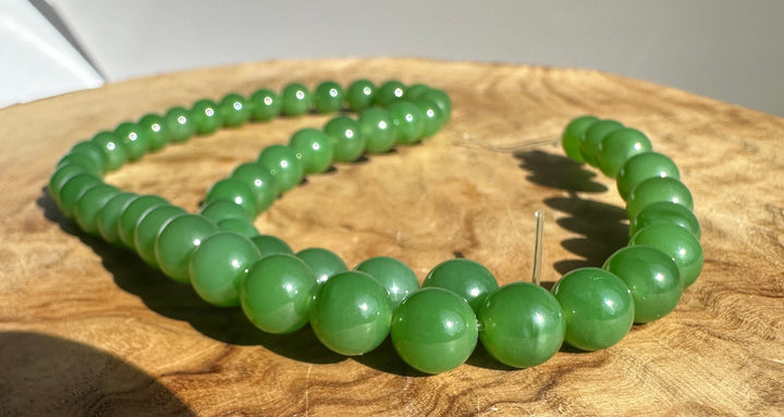 Close up of 8mm AA grade Siberian jade beads on a string, unstrung 16 inch strand