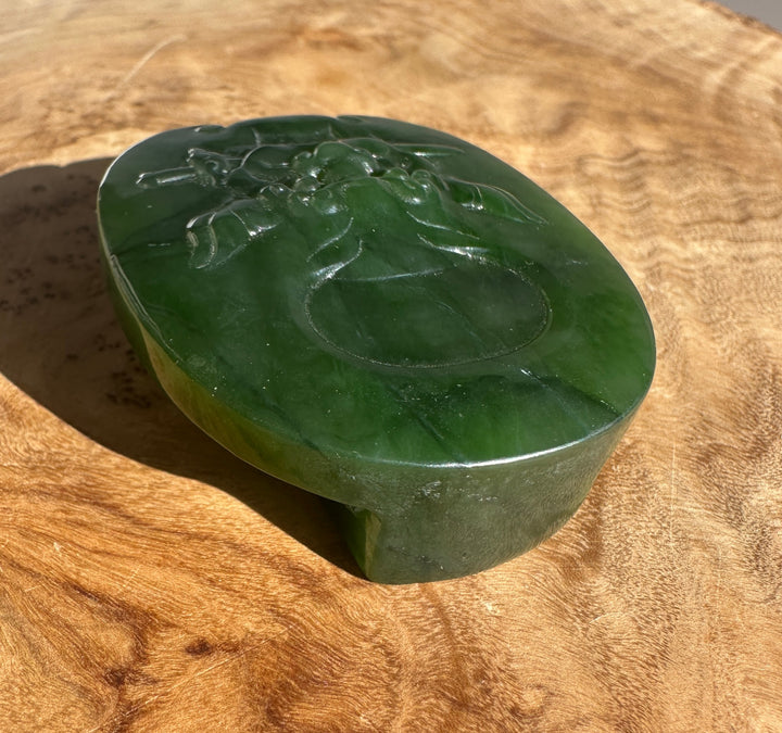 Front view of the jade belt buckle with a detailed carved scene on the surface.
