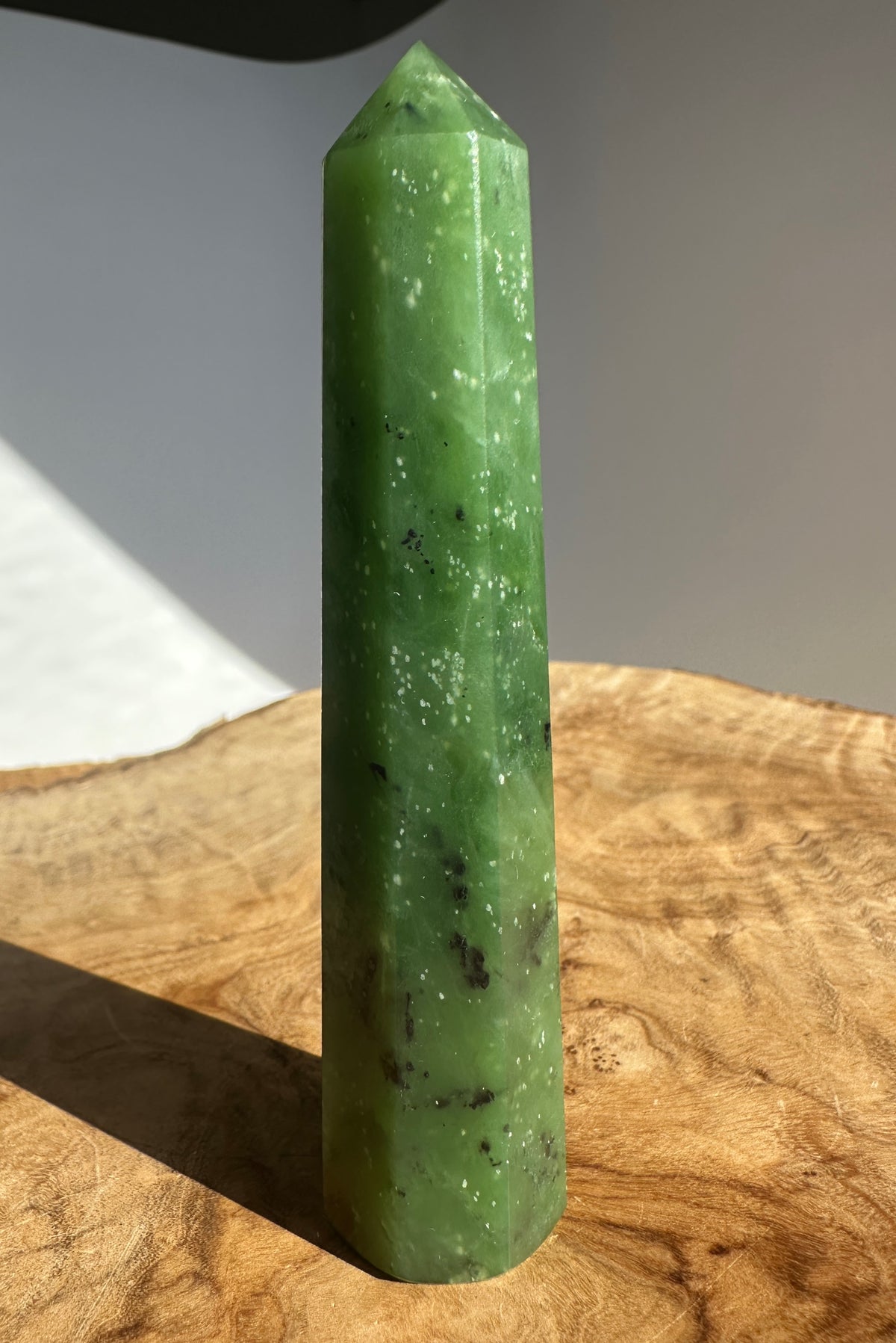 Canadian Ogden Jade 4.25 inch tower obelisk in vivid green standing upright on a wood surface